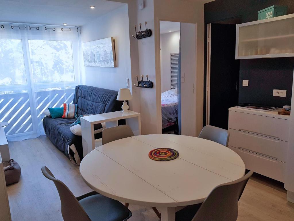 ein kleines Wohnzimmer mit einem Tisch und einem Sofa in der Unterkunft appartement à 300m de la plage in Saint-Georges-de-Didonne
