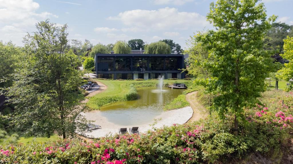 a building with a pond and a fountain at La Marquise luxe vakantiehuis in Budel