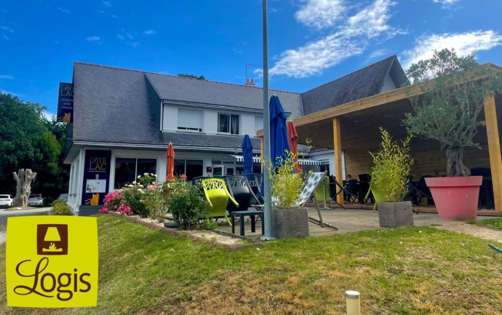 ein Haus mit einem Stellenanzeiger davor in der Unterkunft Hôtel Restaurant Logis Coté Lac in Savenay