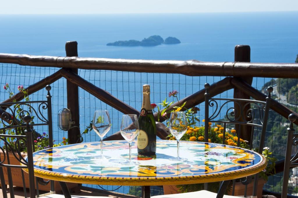 un tavolo con due bicchieri e una bottiglia di vino di Villa Graziella Positano "a Piece of Paradise" a Positano