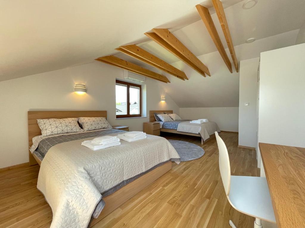 a bedroom with two beds and a table and chairs at Apartment ANMARI in Radovljica