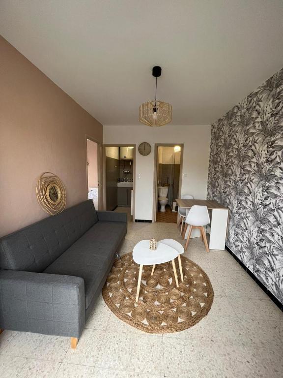 un salon avec un canapé et une table dans l'établissement magnifique appartement en bord de mer, à Valras-Plage