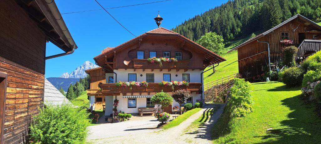 a house on a hill with flowers on it at BioBauernhof Fresoldhof in Schladming