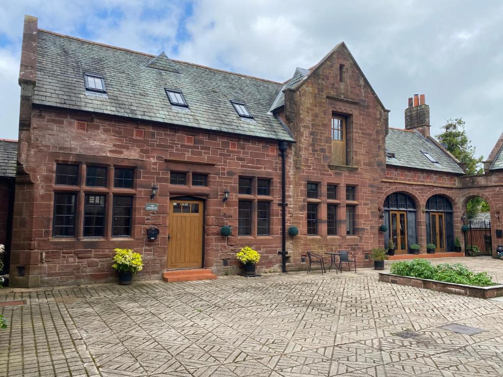 a large brick building with a brick courtyard at The Stables in Frizington
