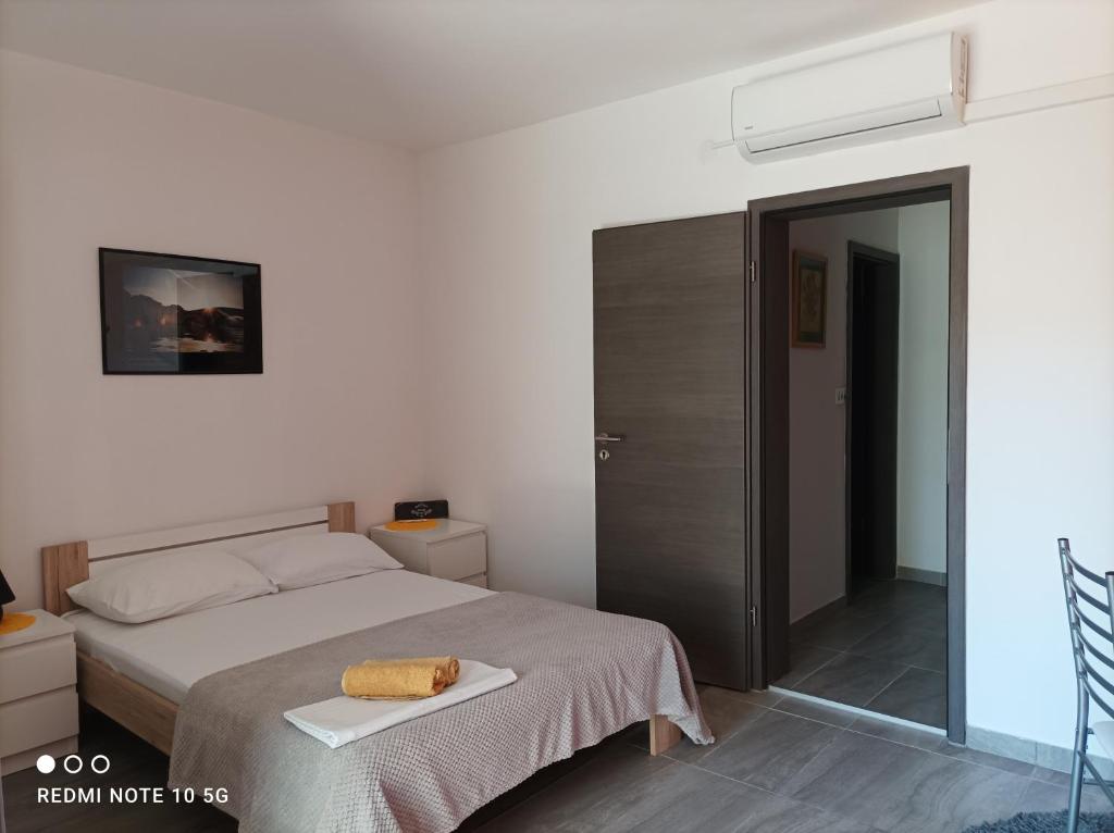 a bedroom with a bed and a sliding glass door at Apartmani Pablo in Pag