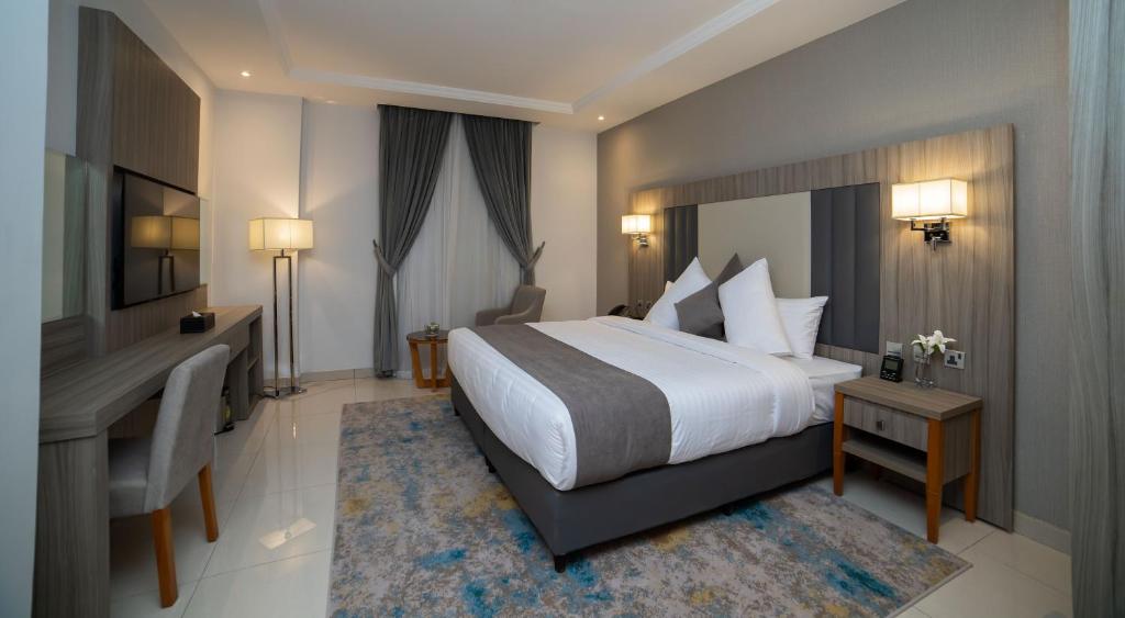 Habitación de hotel con cama, escritorio y escritorio. en Romera Hotel en Yeda