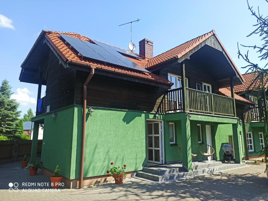 a house with a roof that is painted green at Zielony Zakątek nad Jeziorem in Danowskie