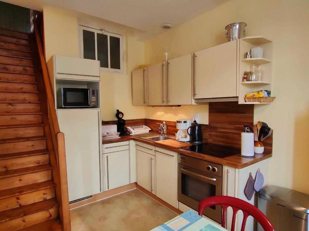 eine Küche mit weißen Schränken und einem weißen Kühlschrank in der Unterkunft Appartement Cauterets, 3 pièces, 4 personnes - FR-1-234-179 in Cauterets