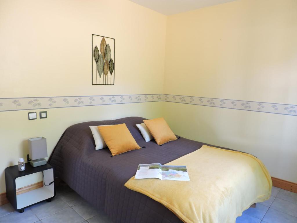 une chambre avec un grand lit avec des oreillers jaunes dans l'établissement Chalet Mélèze - Les Chalets de Barruérot - Spa jacuzzi privatif - Piscine en été, à Peyrusse-Grande