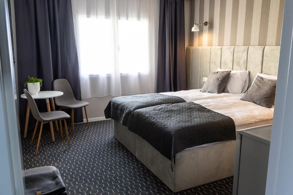 una camera d'albergo con letto, tavolo e sedie di Pensjonat Dana a Dziwnów