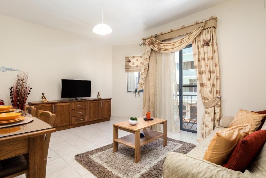 a living room with a couch and a tv at Spacious, Bright & Cosy 2 Bedroom 2 Bathroom Apartment - Msida Uni Heights in Msida