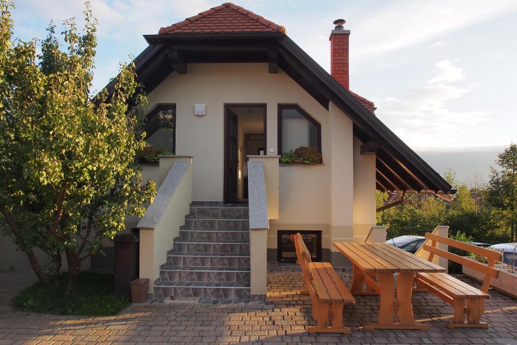 uma pequena casa com uma mesa e dois bancos em Apartment Knap em Cerknica
