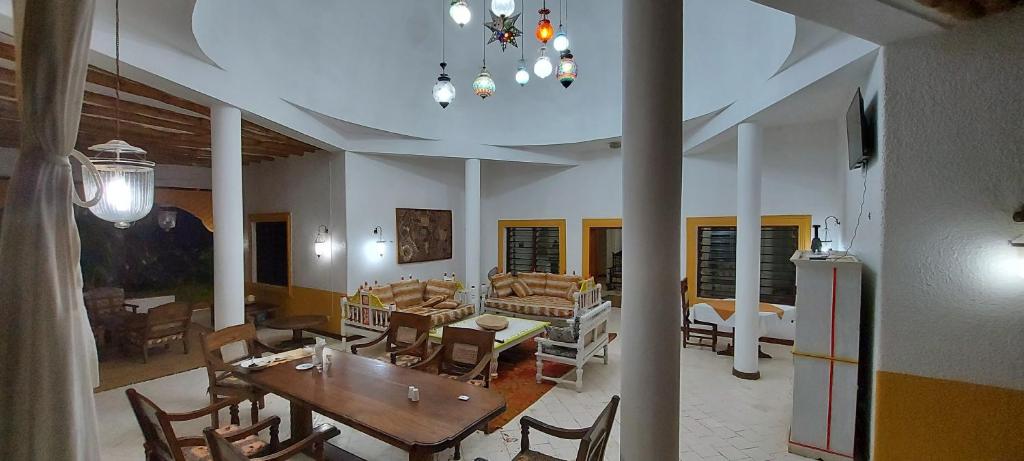 Villa Mela, Malindi في ماليندي: غرفة معيشة مع طاولة وغرفة طعام
