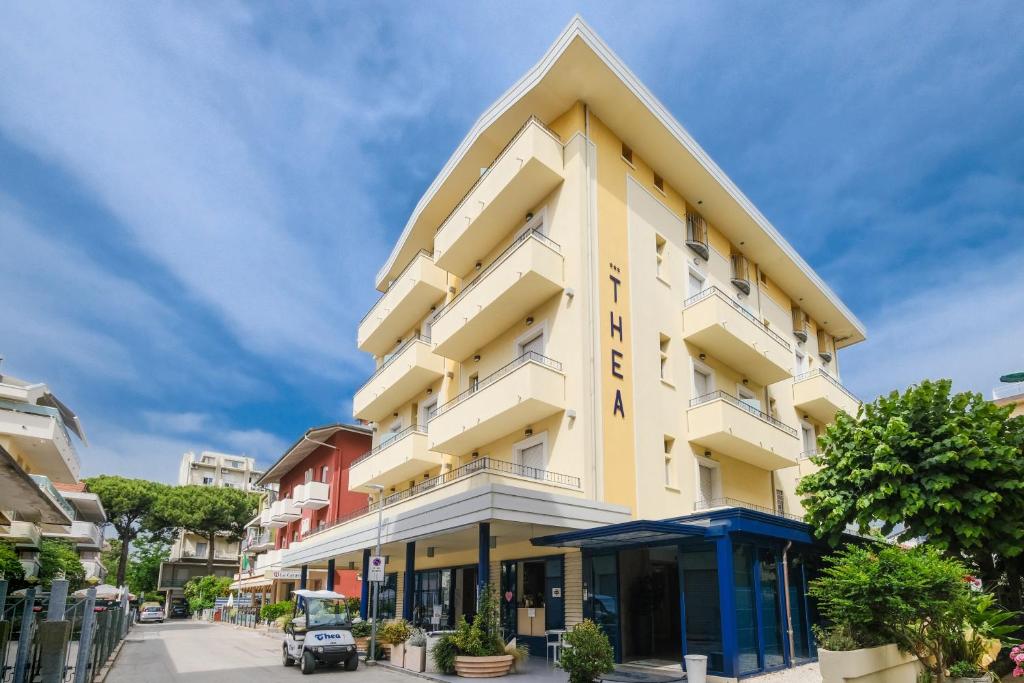 um edifício amarelo alto com um topo de triângulo em Hotel Thea em Bellaria-Igea Marina