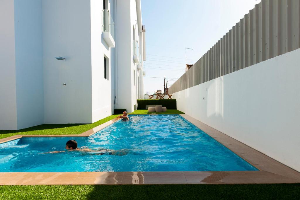 two children playing in a swimming pool in a house at Sport Hotel A Seleção in Setúbal