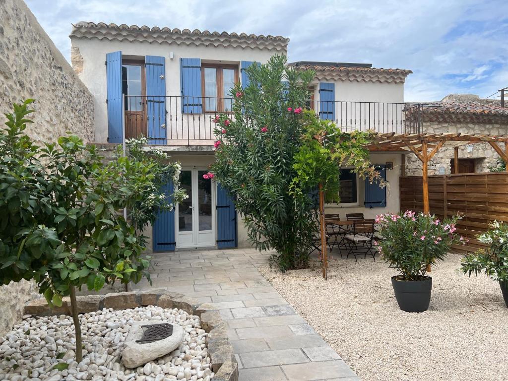 ein Haus mit blauen Türen und einer Terrasse in der Unterkunft Le Mas de la Vinçane in Pernes-les-Fontaines