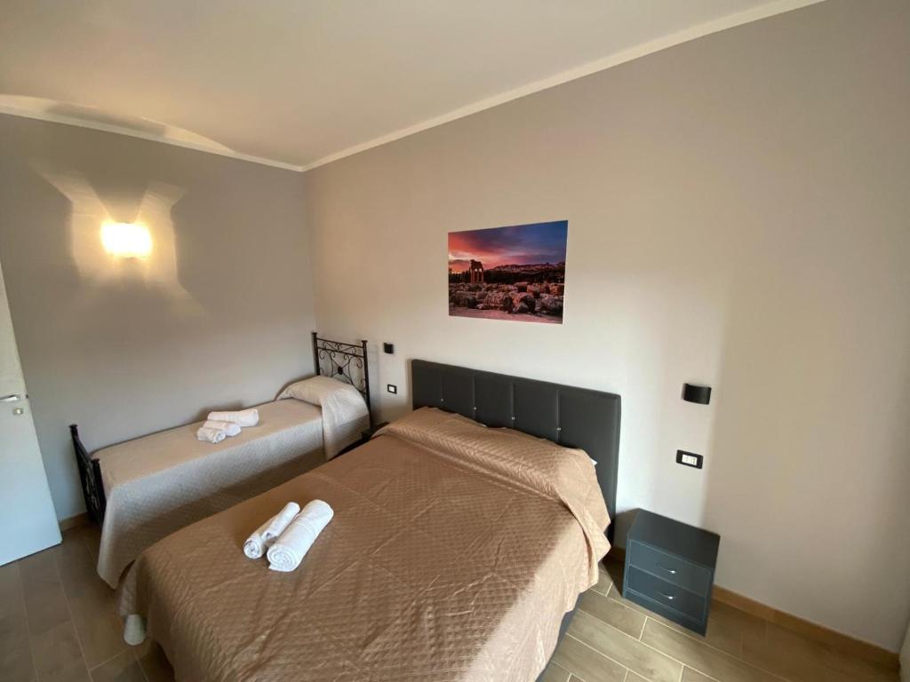 1 dormitorio con 2 camas y un cuadro en la pared en B&B My Home, en Agrigento