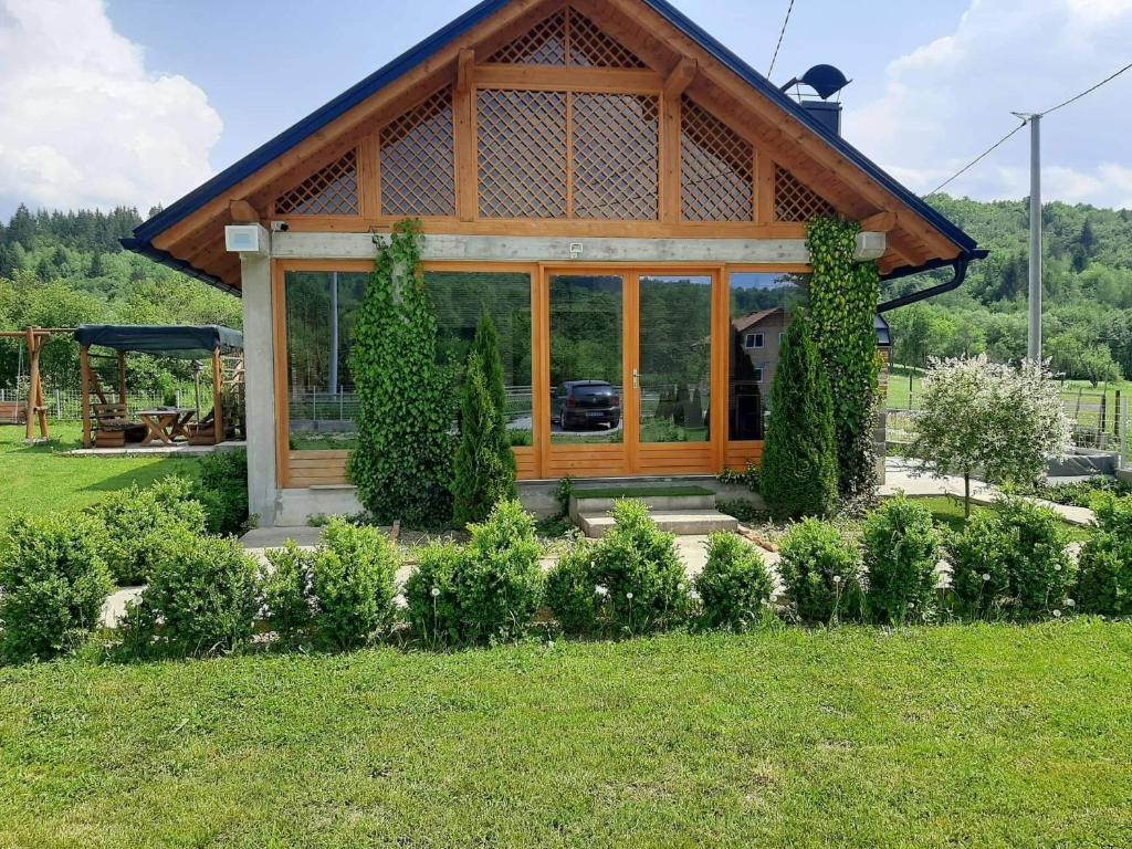 ein großes Holzhaus mit Glasfenstern im Hof in der Unterkunft Vikendica Twins in Donji Vakuf