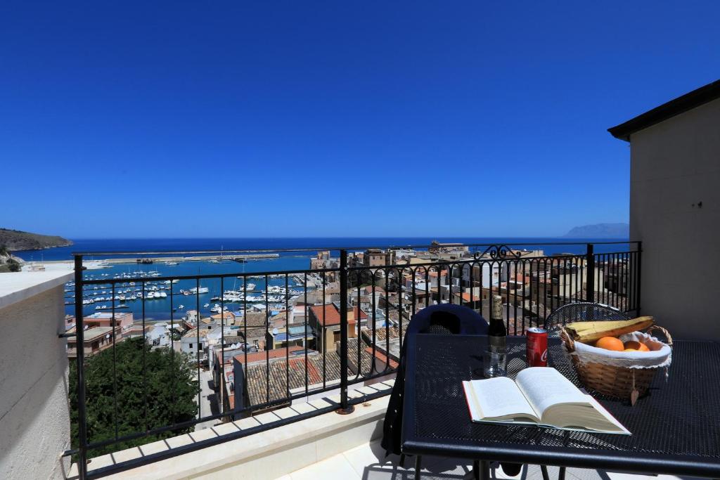 een balkon met een tafel met boeken en uitzicht op de oceaan bij Sicilia Ovest - Sea View Terrace Dolce Vita in Castellammare del Golfo