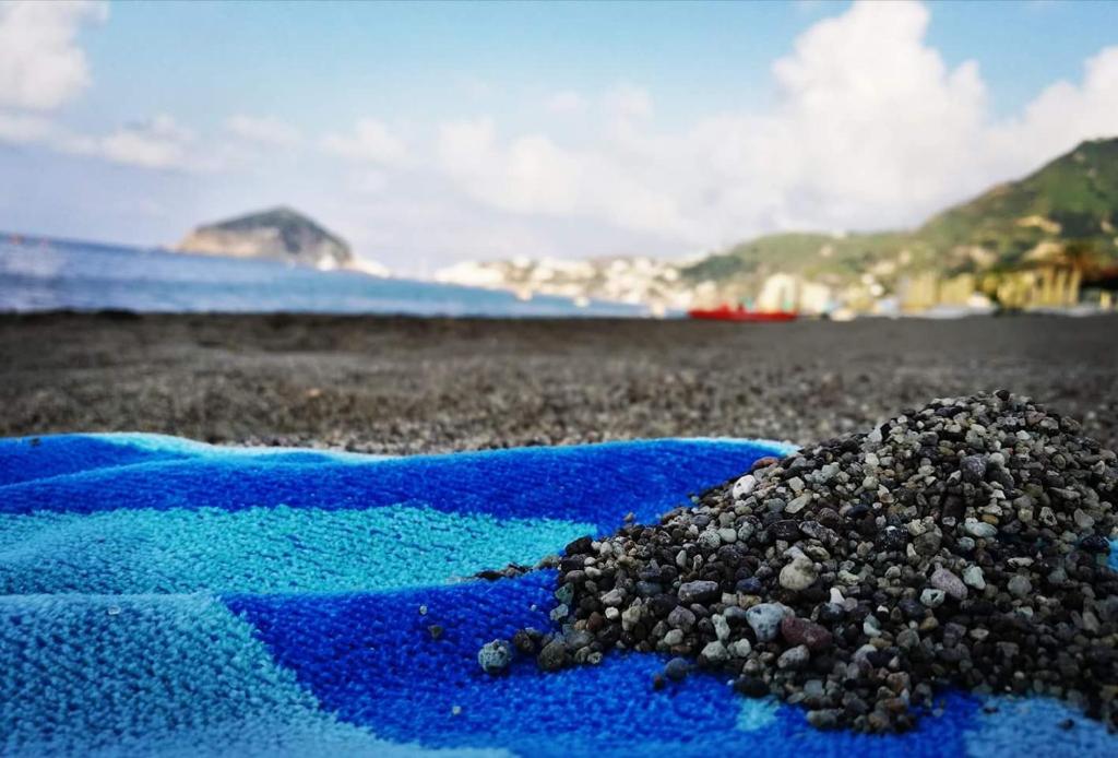 un mucchio di ghiaia su un telo blu su una spiaggia di Blu Maronti a Ischia