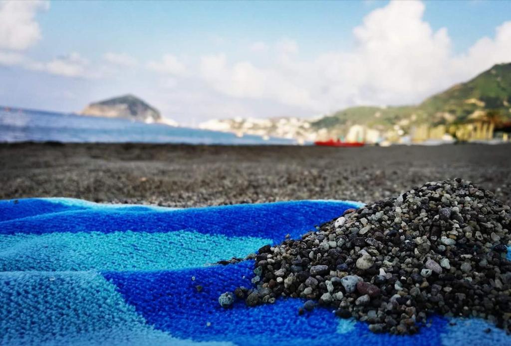 a pile of gravel on a blue towel on a beach at Blu Maronti in Ischia