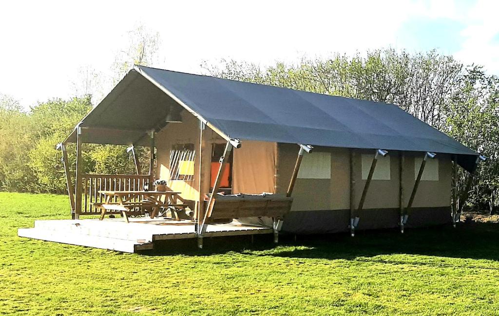 uma tenda com uma mesa e cadeiras num campo em Safaritent Lodge 5 em Ruurlo