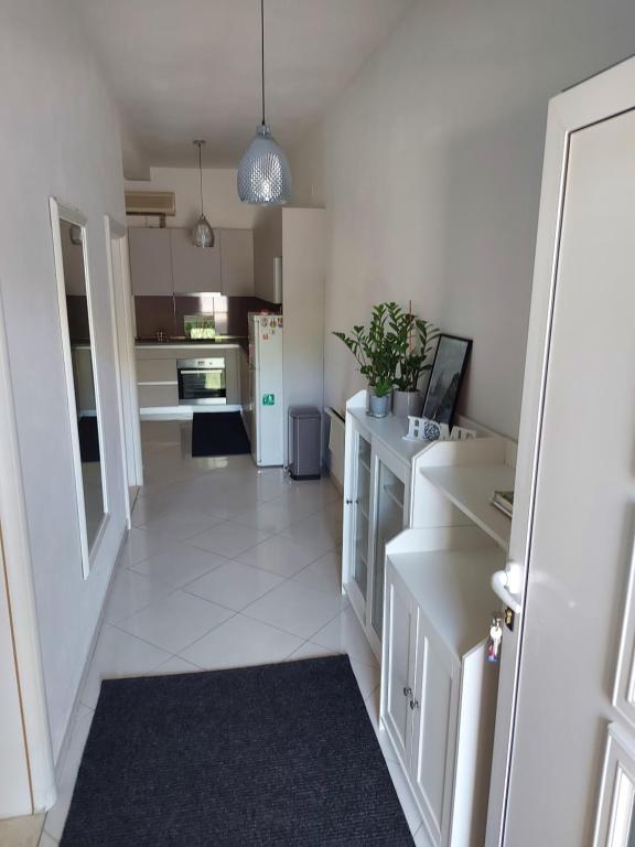 a kitchen with white cabinets and a white tile floor at Vita Style in Kaštela
