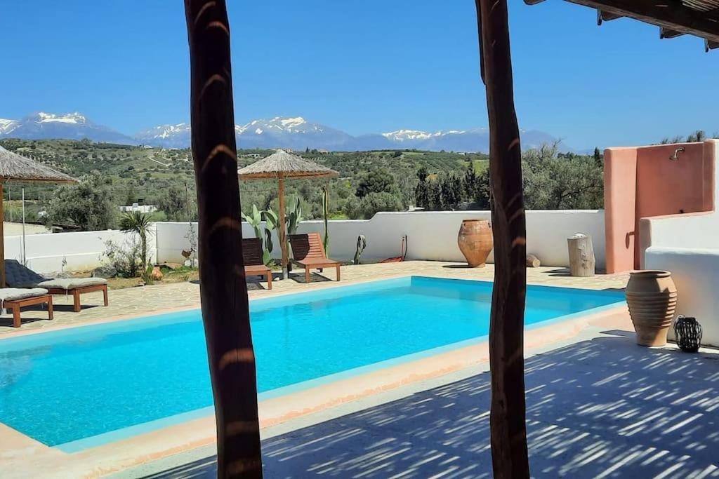 uma piscina numa villa com montanhas ao fundo em Villa Louloudia stylish luxury villa with private pool em Pitsídia