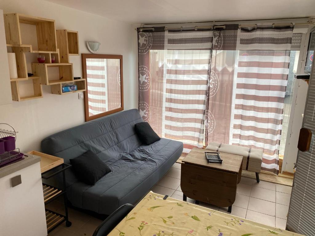 - un salon avec un canapé bleu et une table dans l'établissement Appartement rdc calme6 pers, à Eaux-Bonnes