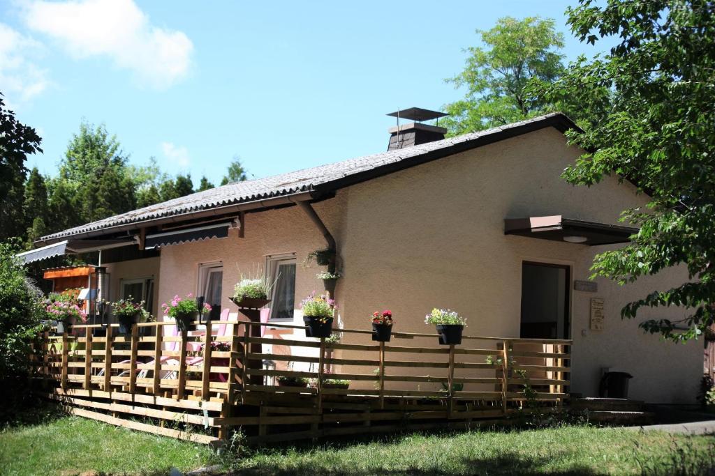 une maison avec des plantes en pot sur une clôture en bois dans l'établissement Haus 6, à Fichtelberg