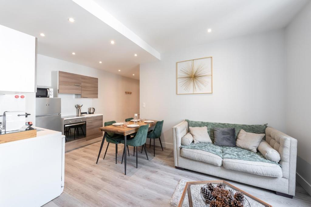 a living room and kitchen with a couch and a table at LE POMPADOUR - Magnifique T2 Place Bellecour 4ème étage sans ascenseur - 4th floor no elevator in Lyon