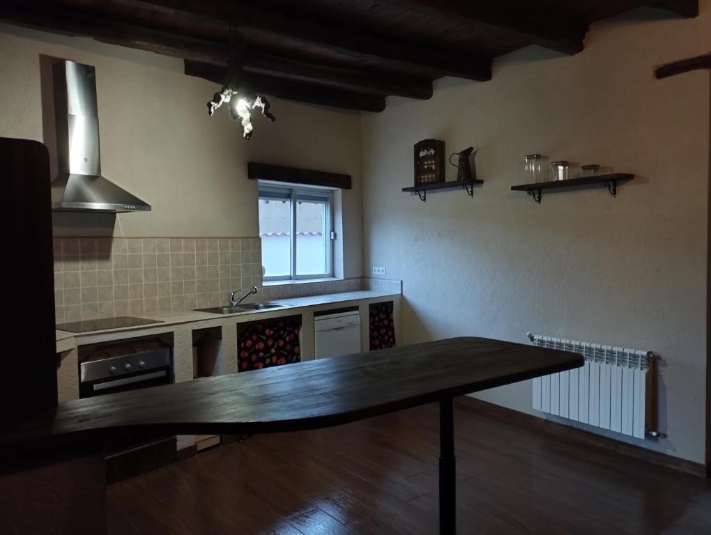 uma cozinha com uma mesa de madeira num quarto em CASA RURAL VEGASAN em Santa Colomba de la Vega