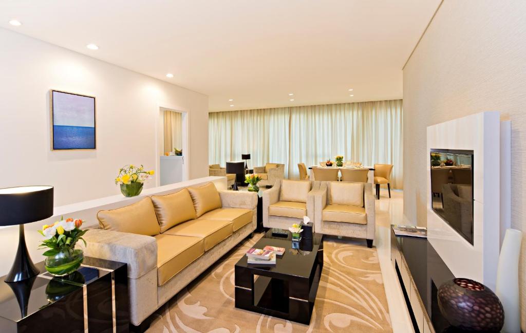 a living room with a couch and a table at DAMAC Maison Canal Views in Dubai