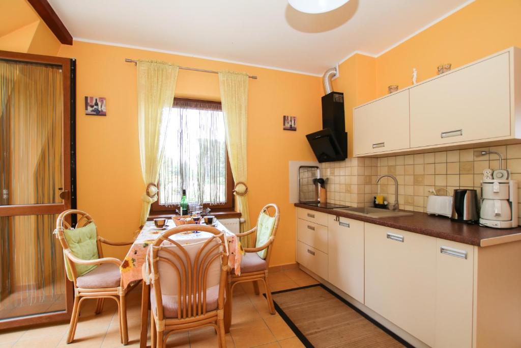 a kitchen with a table and chairs in a room at Apartment Afryka in Rewal