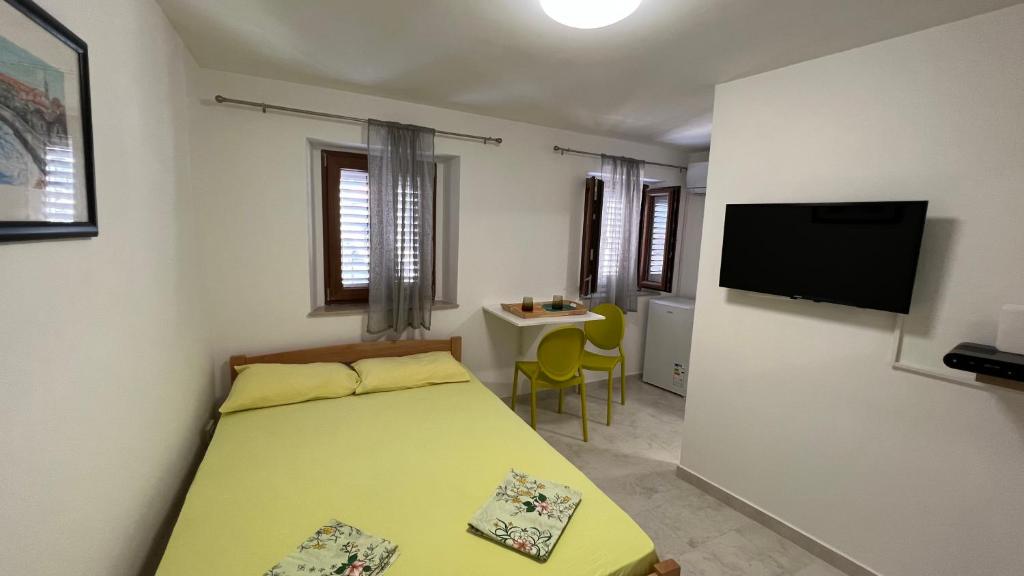 布德瓦的住宿－T&S ROOM，一间卧室配有一张床、一张桌子和一台电视。