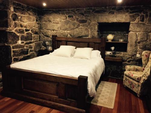 1 dormitorio con cama y pared de piedra en Casa o Cantón, 