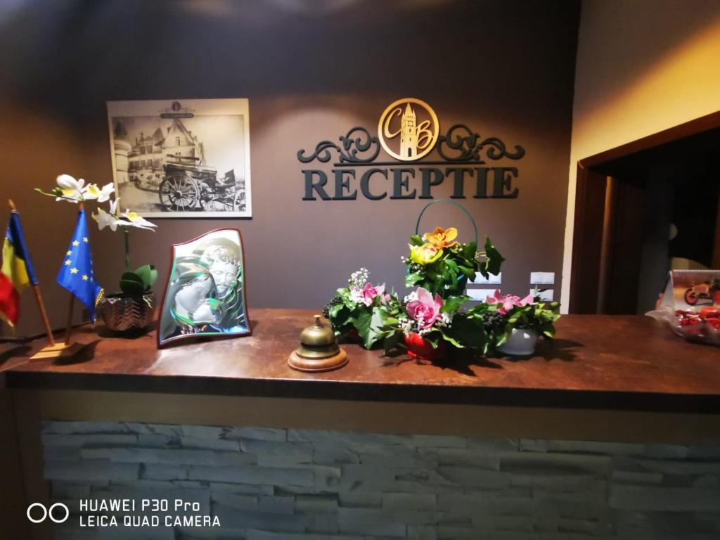 a counter with flowers and a sign on the wall at Casa Baimareana in Baia Mare