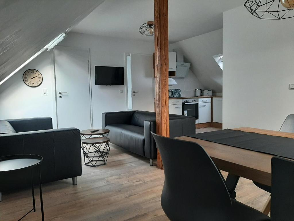 Una sala de estar con mesa de comedor y una cocina. en Ferienwohnung Muh - Ostfriesland nähe Nordsee, en Rechtsupweg