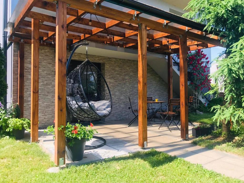 a patio with a swing under a wooden pergola at Apartament u Doroty in Augustów