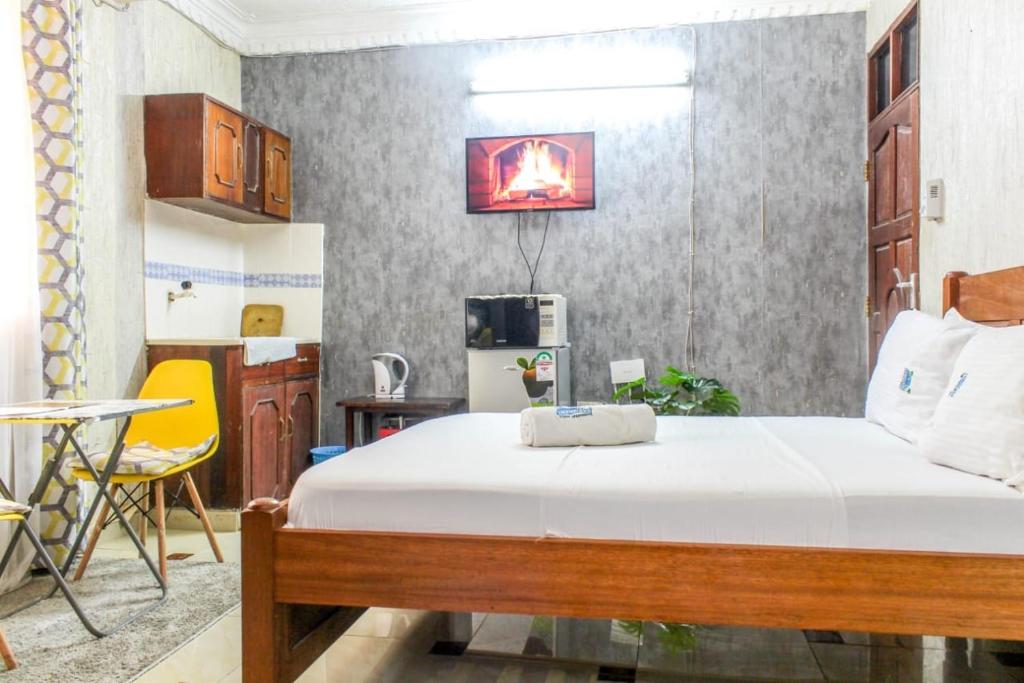 a bedroom with a bed and a table and a chair at Sea Esta suite 47 in Mombasa