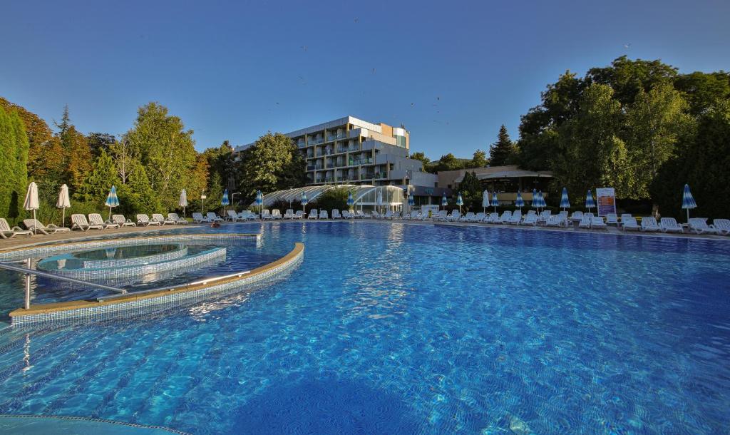 a large swimming pool with chairs and a building at Hotel PrimaSol Ralitsa Superior in Albena