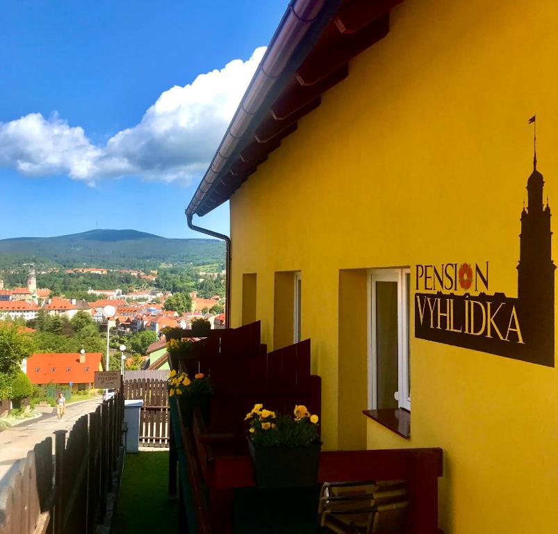 un edificio amarillo con una señal que lee la pasión willka en Pension Vyhlídka, en Český Krumlov