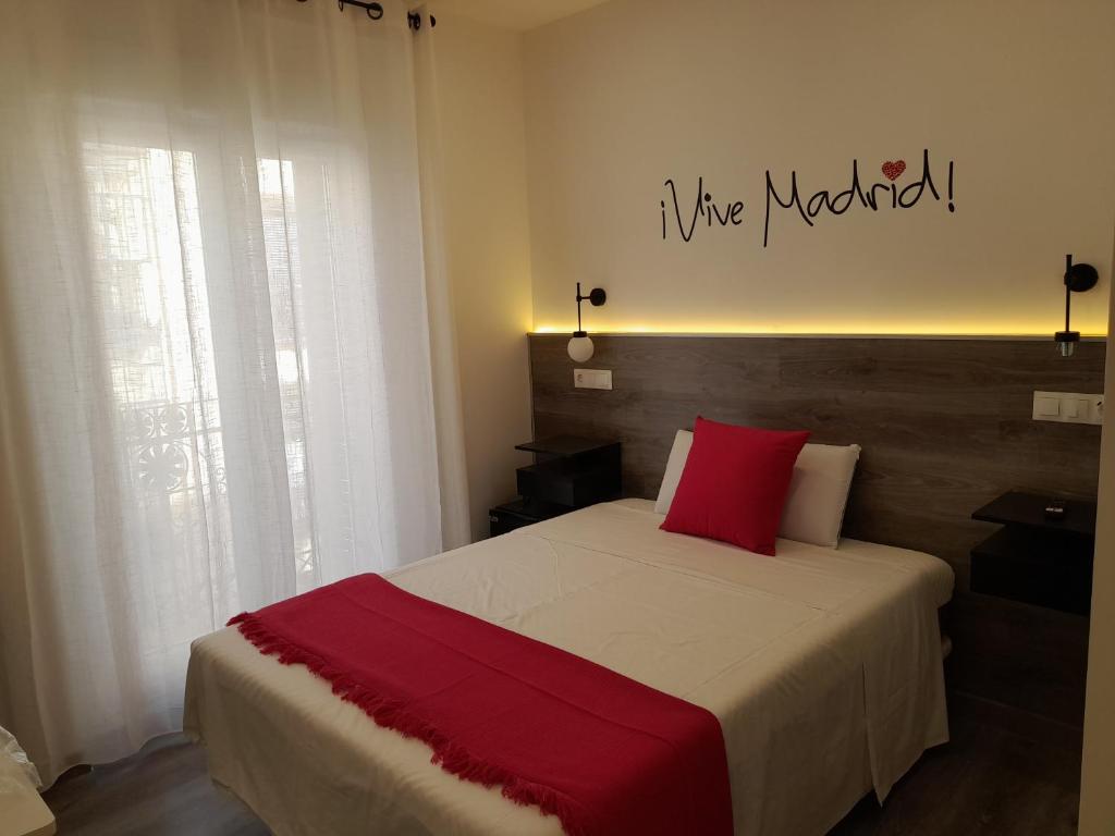 1 dormitorio con cama grande y almohada roja en CH Bueno en Madrid