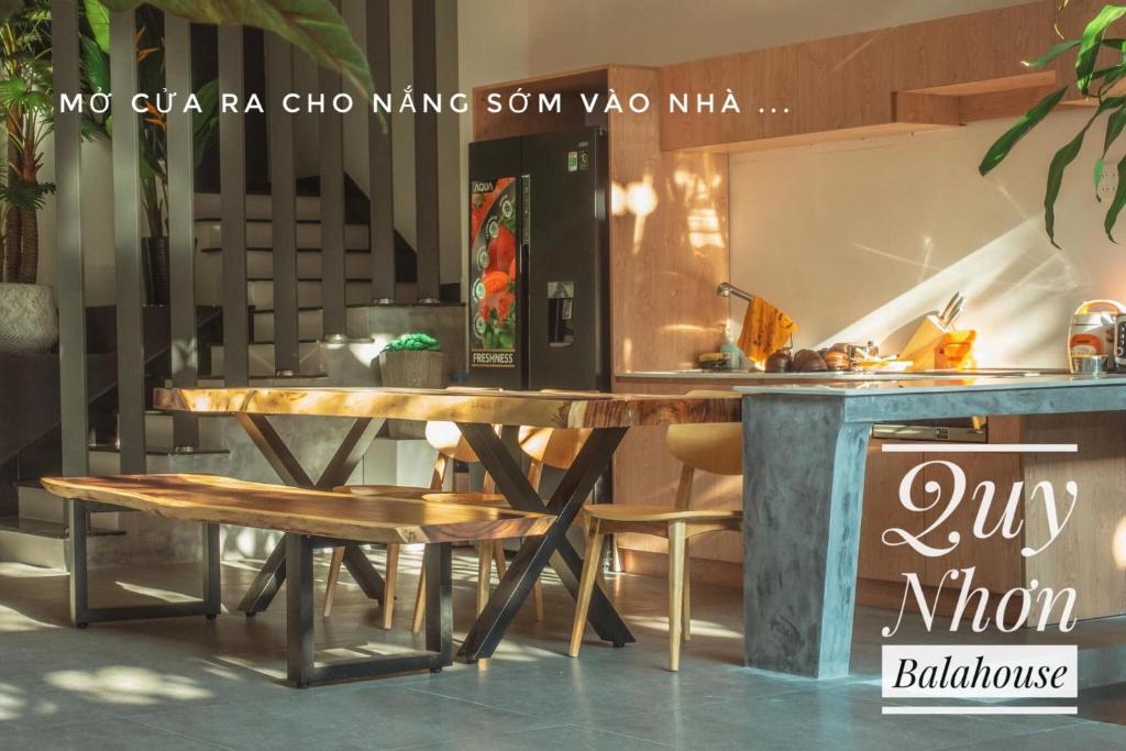 歸仁的住宿－Quy Nhơn Balahouse，厨房里配有一张木桌和椅子