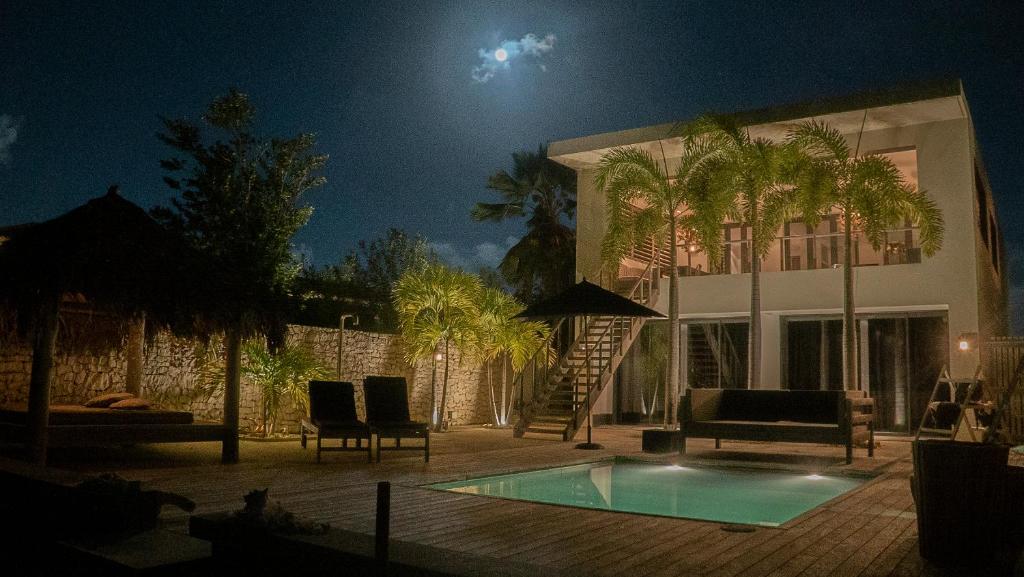 ein Haus mit einem Swimmingpool vor einem Gebäude in der Unterkunft OCEANFRONT VILLA WITH ACCES CARIBBEAN SEA in Kralendijk