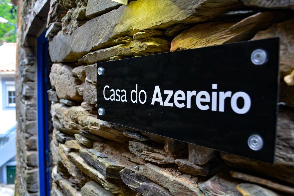 a sign on the side of a stone wall at Casa do Azereiro in Casal do Rei