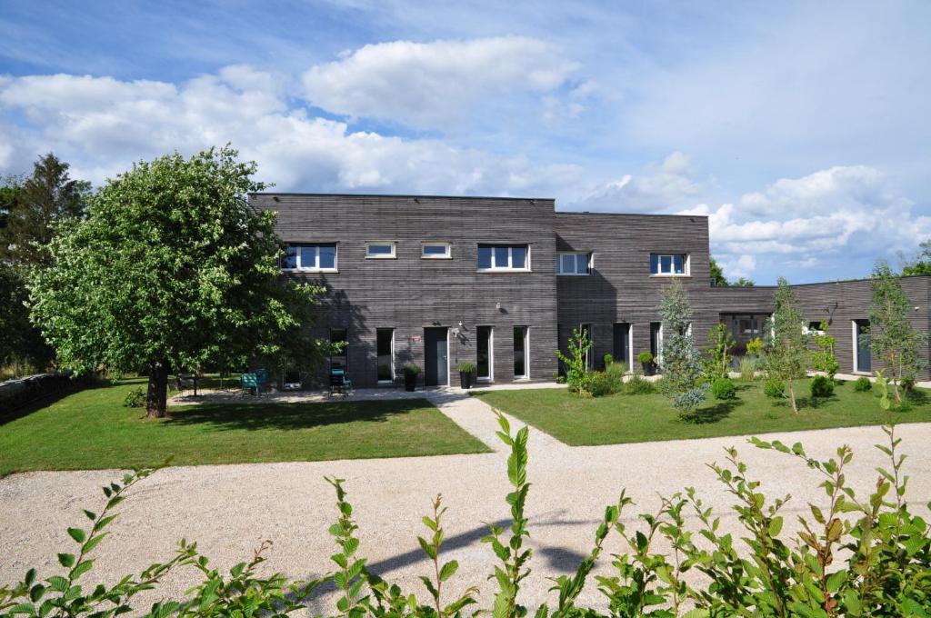 um grande edifício de tijolos com um jardim em frente em L'Atelier em Sainte-Marie-du-Lac-Nuisement 