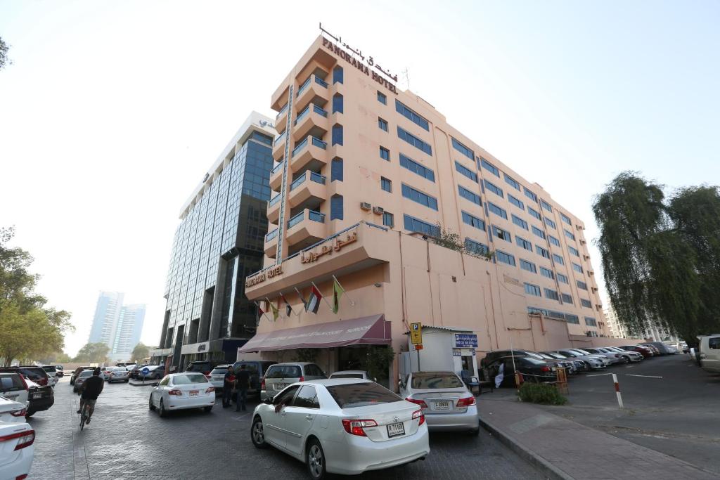 un grand bâtiment avec des voitures garées dans un parking dans l'établissement Panorama Hotel Bur Dubai, à Dubaï