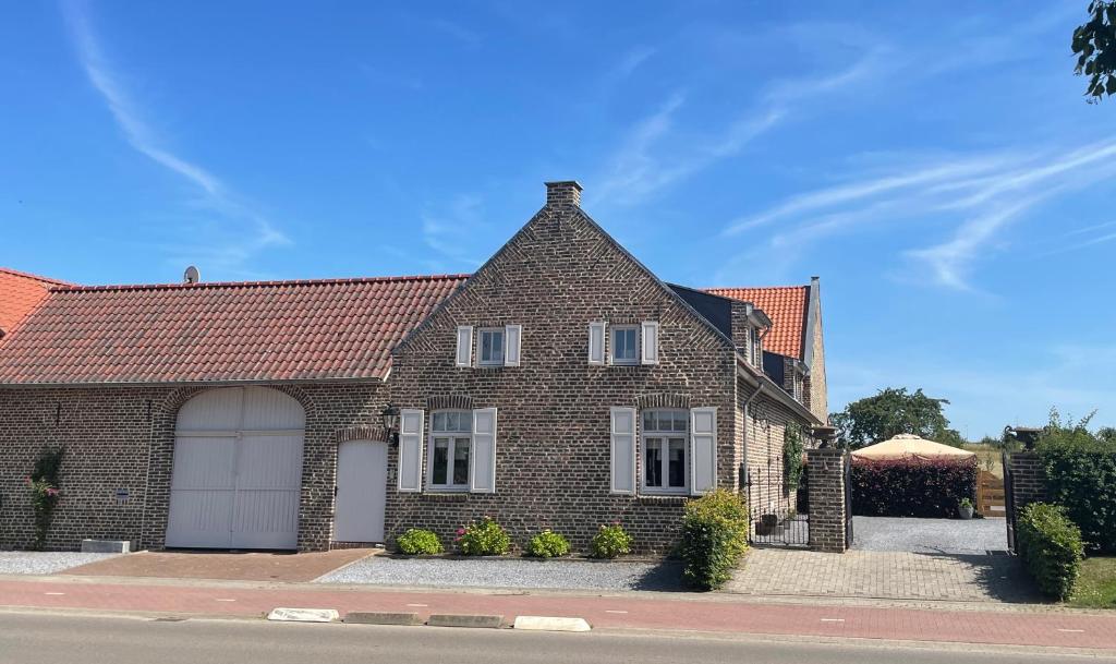 een stenen huis met een witte garage bij B&B Aasterbergerhoeve in Echt