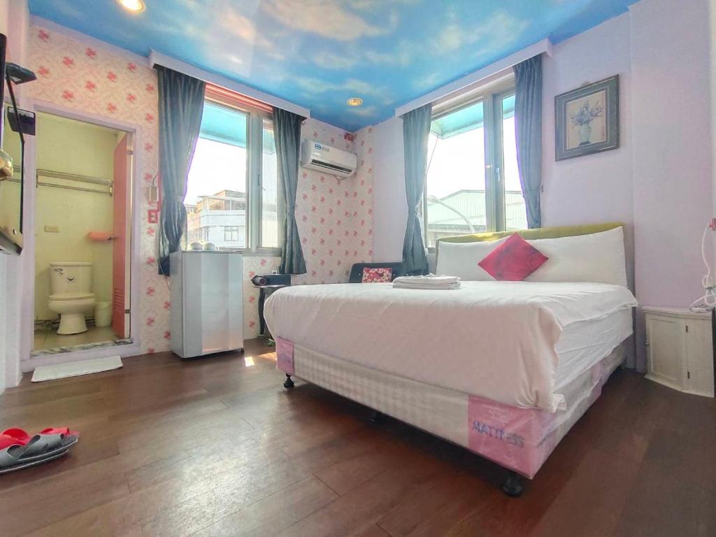 a bedroom with a large bed and a bathroom at Lantian Baiyun in Hualien City